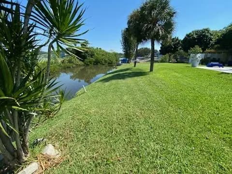 Mowed lawn sloping down to a pond